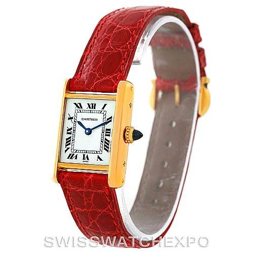 The Tank Classic by Cartier is shown at an angle highlighting the gold rectangular case, white dial with Roman numerals, and red leather strap.