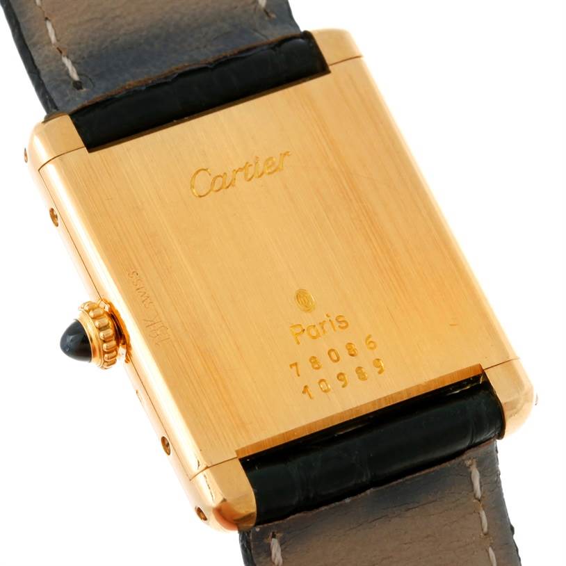 The image shows the back and crown of the Cartier Tank Classic Yellow Gold White Dial Yellow Gold White Dial watch with the serial numbers visible.