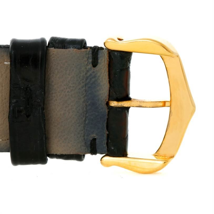 The image shows a close-up of the buckle and part of the leather strap of a Cartier Tank Classic Yellow Gold White Dial Yellow Gold White Dial watch.
