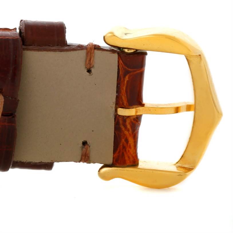 The image shows a close-up of the brown leather strap and gold buckle of a Cartier Tank Classic Women's Yellow Gold Silver Dial Women's Yellow Gold Silver Dial watch.