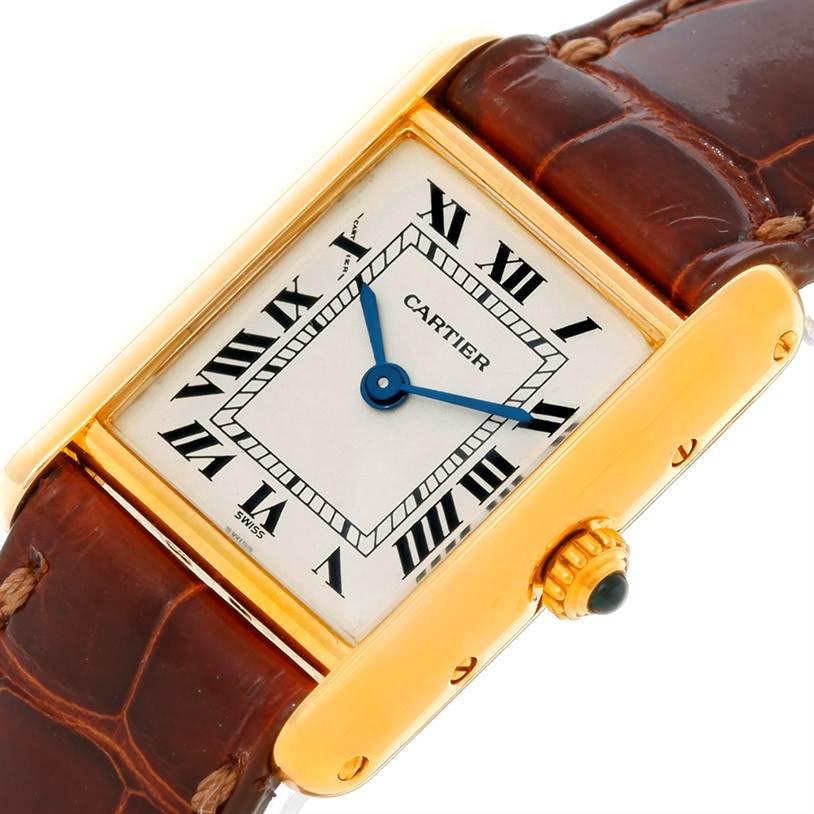 The image shows a top-down view of the Tank Classic model by Cartier, highlighting the rectangular face, Roman numerals, and leather strap.