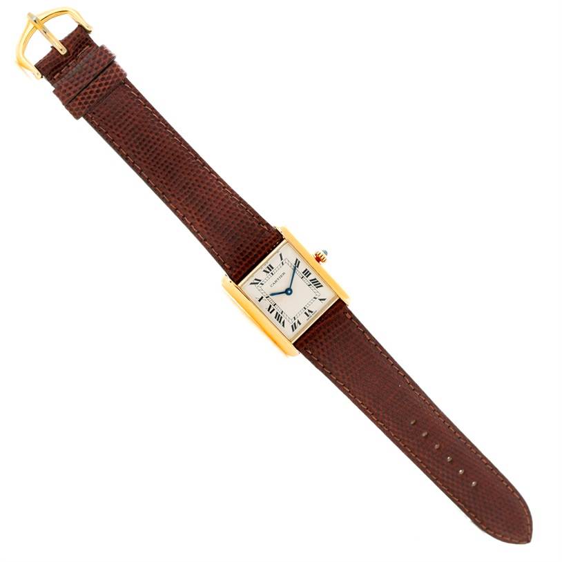 The image shows a Cartier Tank Classic Yellow Gold Beige Dial Yellow Gold Beige Dial watch with a gold rectangular case and a brown leather strap, viewed from above.