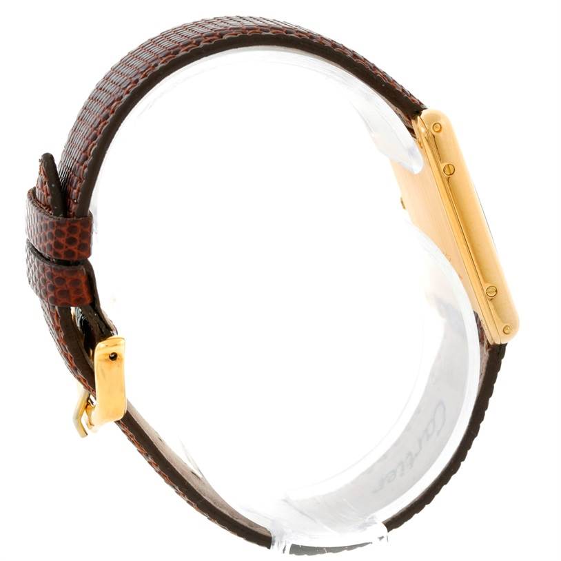 The image shows a side view of the Cartier Tank Classic Yellow Gold Beige Dial Yellow Gold Beige Dial watch, featuring its leather strap and gold case.