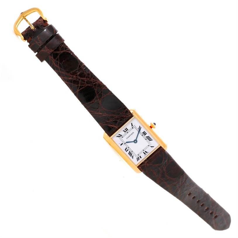 The image shows a top-down view of the Cartier Tank Classic 8810527329 Yellow Gold White Dial 8810527329 Yellow Gold White Dial watch, highlighting its rectangular face, leather strap, and buckle.