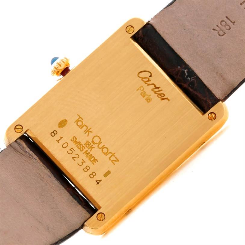 This image shows the back case of a Cartier Tank Classic 8810527329 Yellow Gold White Dial 8810527329 Yellow Gold White Dial watch, highlighting the model's engraving and leather strap attachment.
