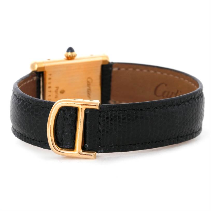 This image shows the back of a Cartier Tank Classic Women's Yellow Gold White Dial Women's Yellow Gold White Dial watch, including the clasp, strap, and part of the watch case.