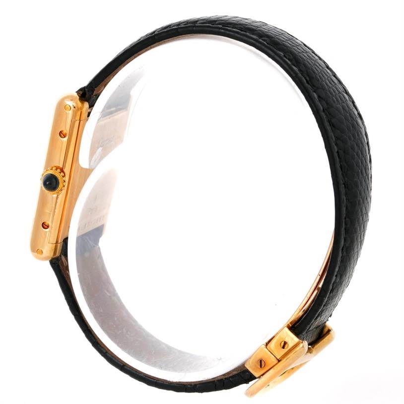 The image shows a side view of the Cartier Tank Classic Women's Yellow Gold White Dial Women's Yellow Gold White Dial watch, highlighting its gold case, crown, and black leather strap.