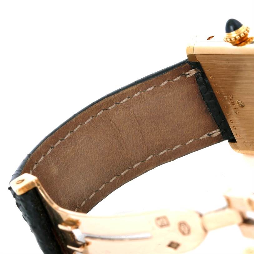 This image shows a close-up of the strap and clasp of a Cartier Tank Classic Women's Yellow Gold White Dial Women's Yellow Gold White Dial watch, highlighting the stitching and part of the gold case.