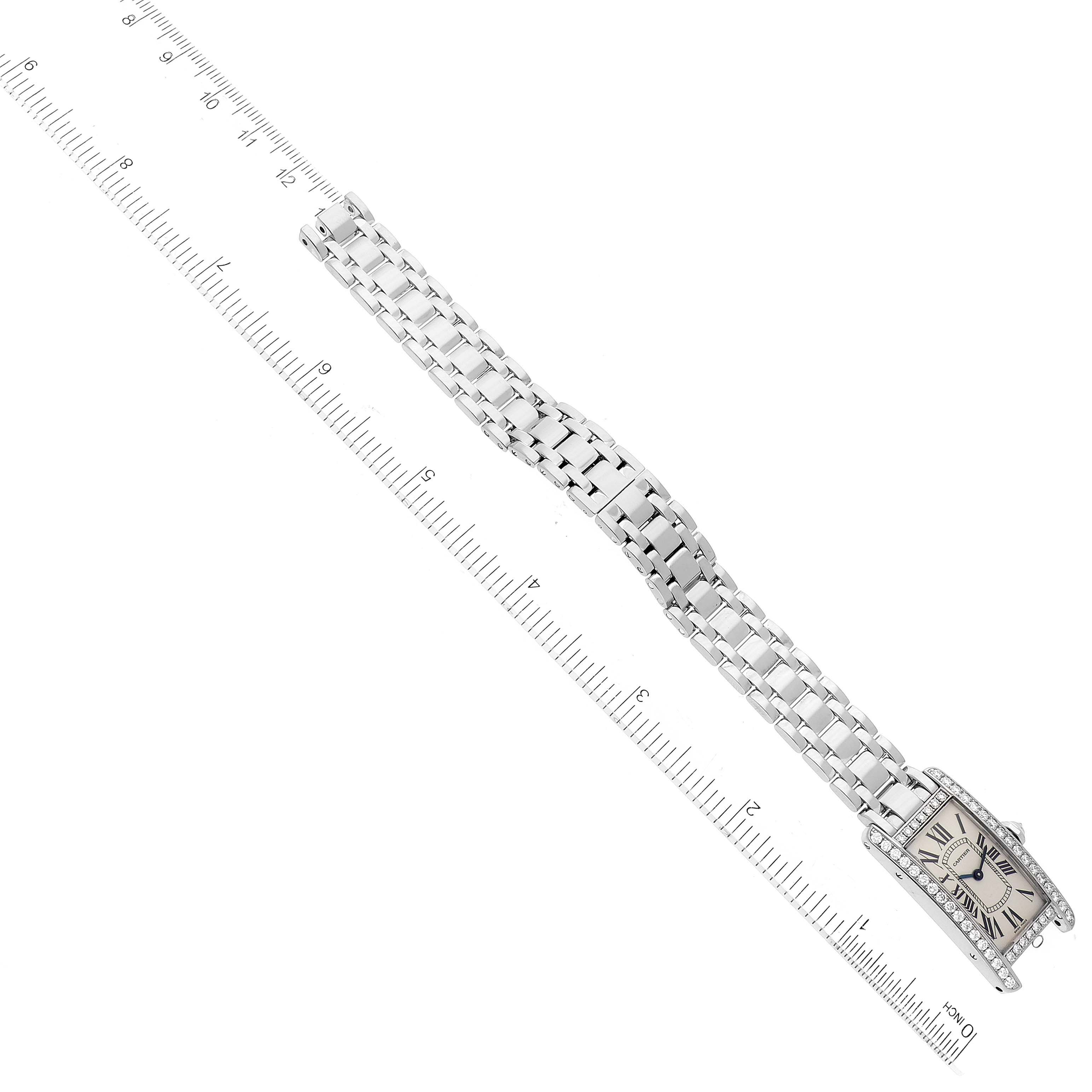 The Cartier Tank Americaine WB7018L1 Women's White Gold Silver Dial WB7018L1 Women's White Gold Silver Dial watch is shown laid flat with its face, bracelet, and clasp visible, accompanied by a ruler for scale.