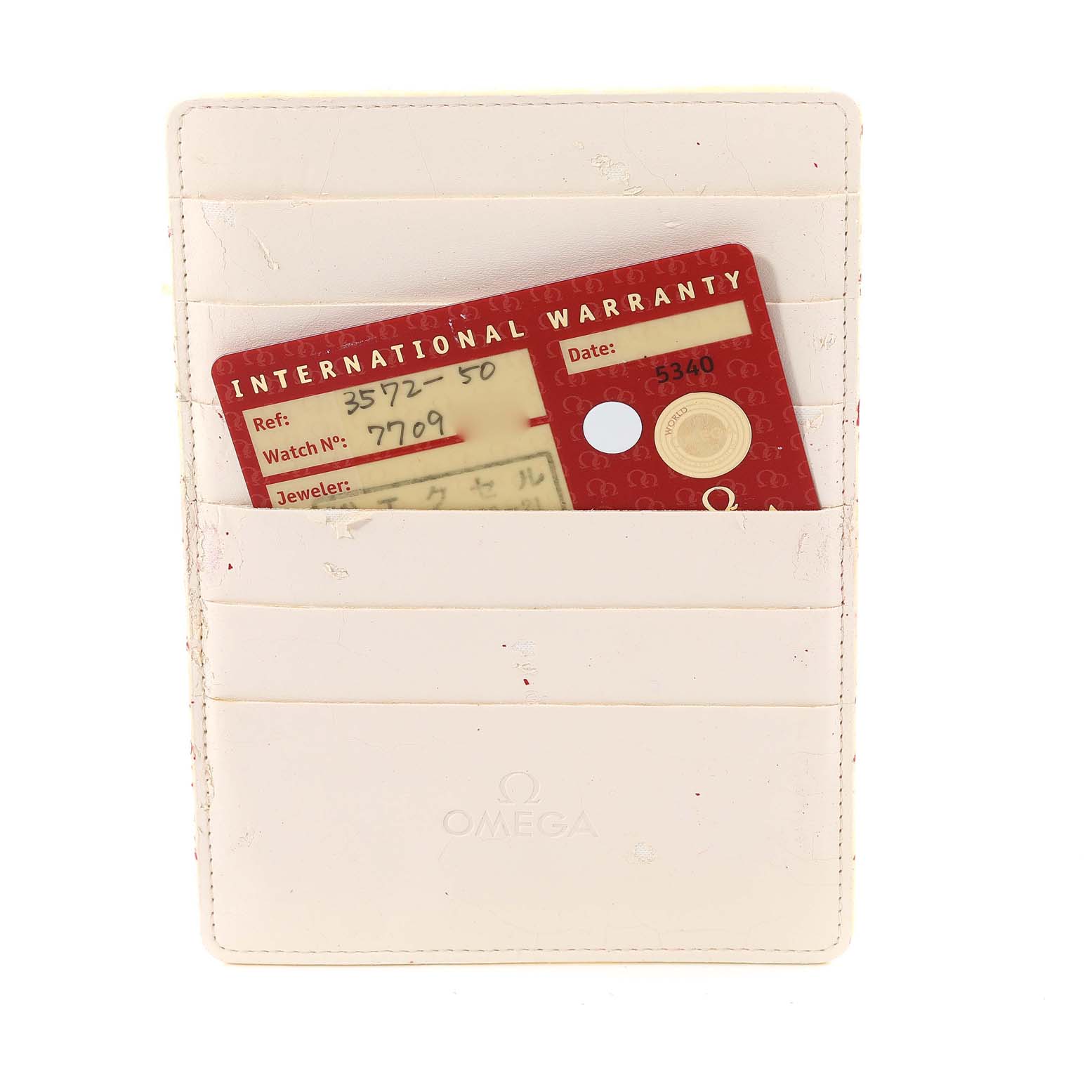 The image shows an Omega Speedmaster 3572.50.00 Men
s Stainless Steel Black Dial 3572.50.00 Men
s Stainless Steel Black Dial
s International Warranty card placed in a white cardholder, photographed from above.