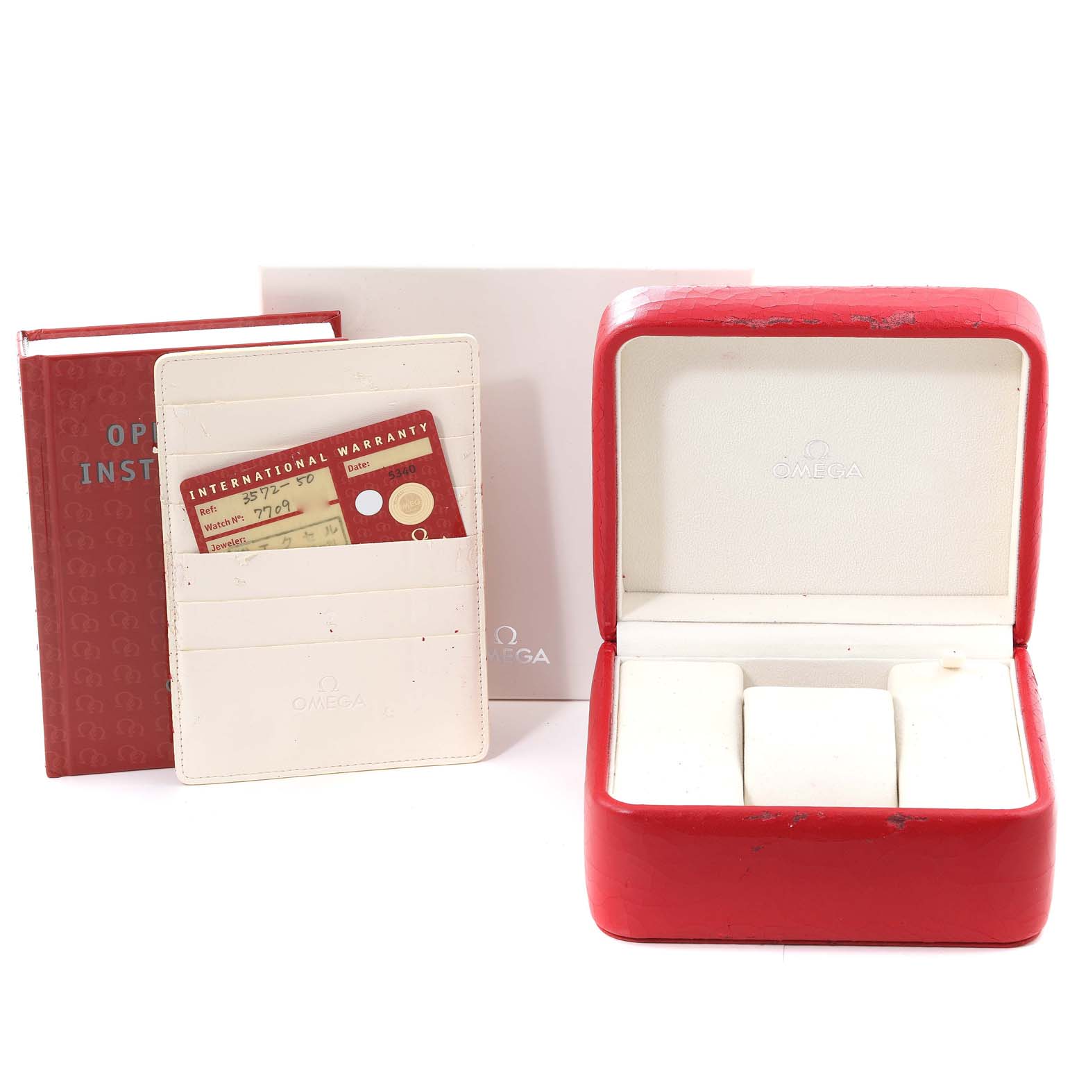 The image shows a red Omega Speedmaster 3572.50.00 Men
s Stainless Steel Black Dial 3572.50.00 Men
s Stainless Steel Black Dial watch box, international warranty card holder, and an operating instruction booklet.