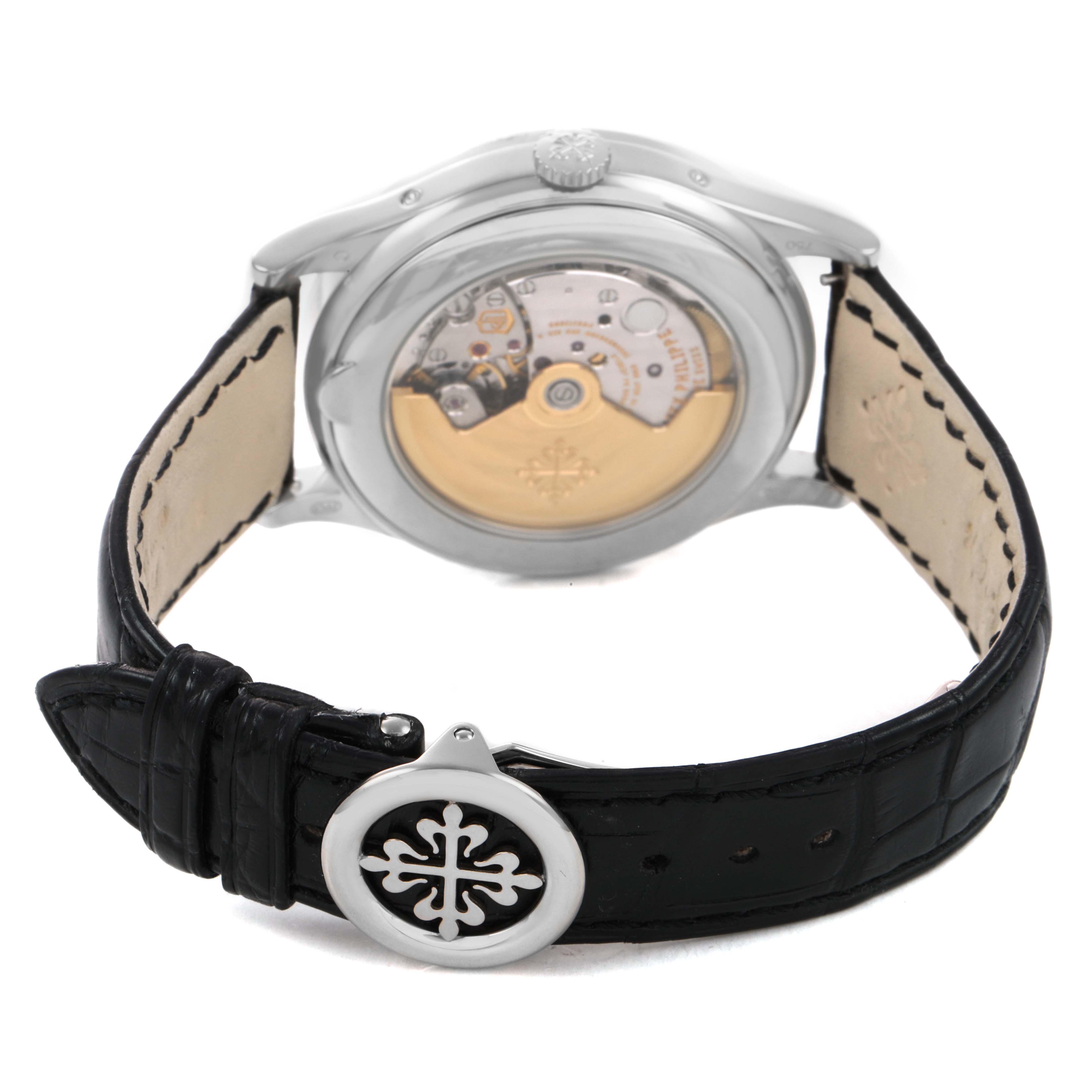 The image shows the back view of a Patek Philippe Complications 5396G-011 Men's White Gold Silver Dial watch, detailing the movement and leather strap with the clasp.