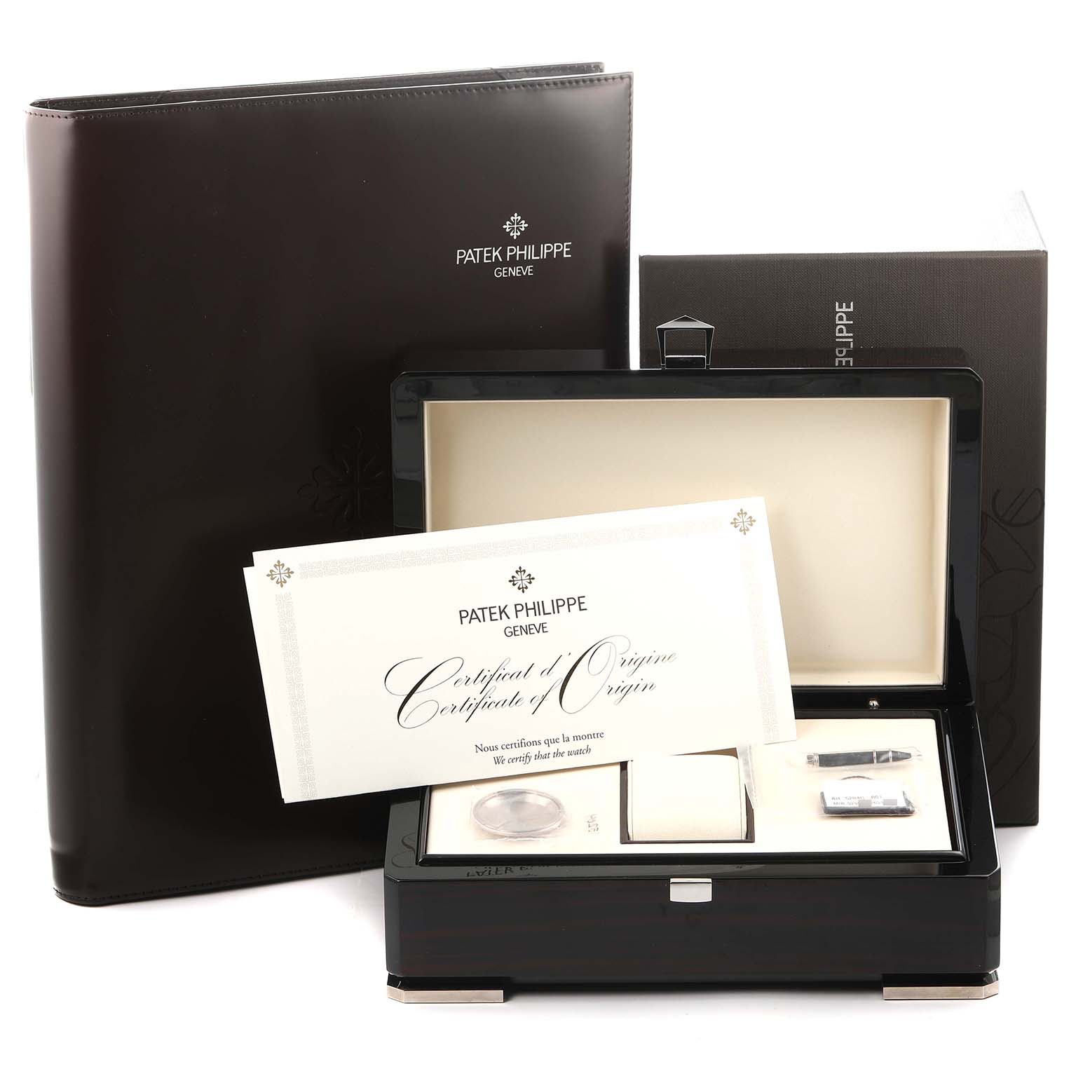 The image shows packaging and accessories for the Patek Philippe Complications watch, model 5204G-001, including a certificate, presentation box, and booklet.