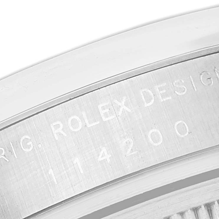 This image shows a close-up of the Rolex Air-King 114200 Men's Stainless Steel Silver Dial 114200 Men's Stainless Steel Silver Dial model's case band with engraved text and reference number 114200.