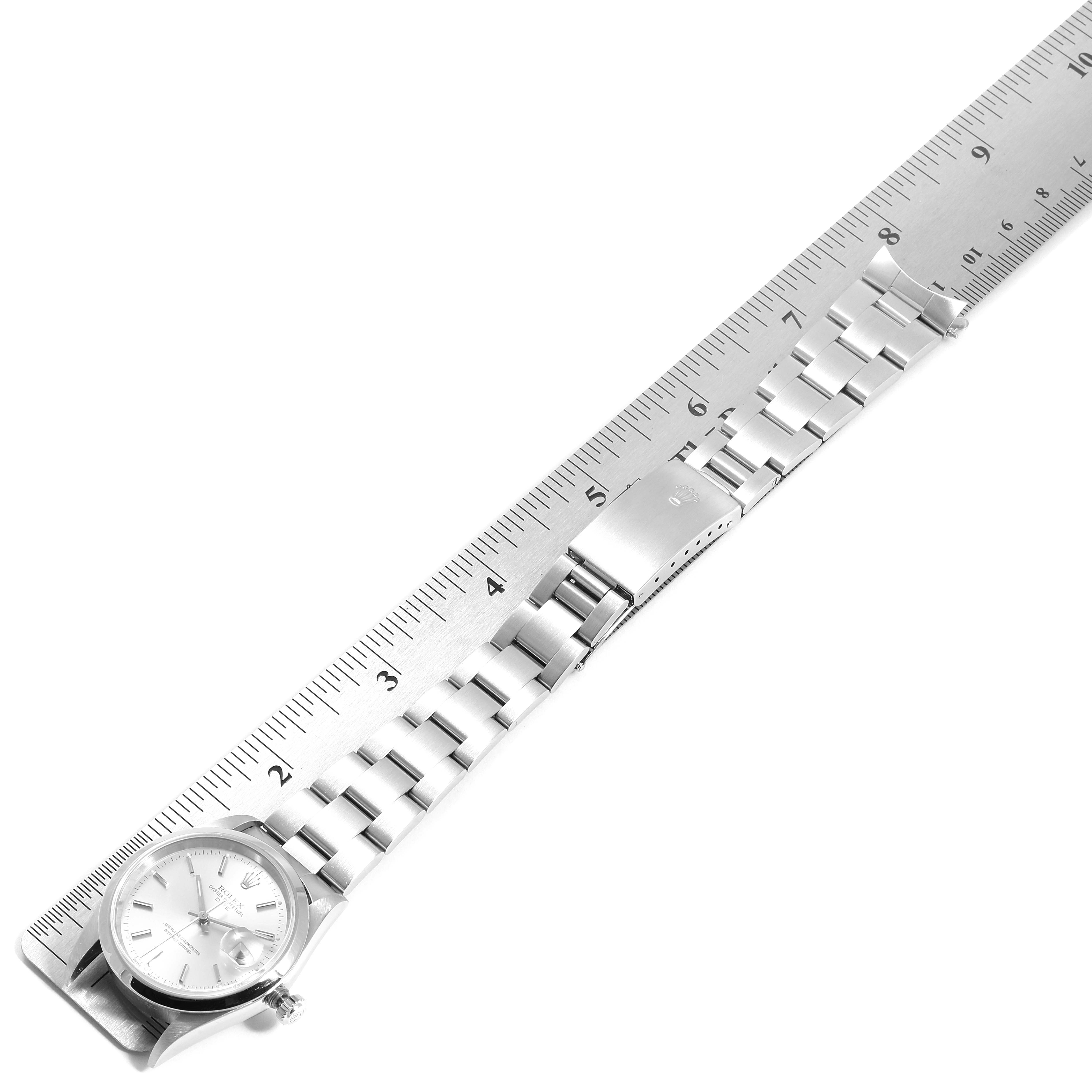 This image shows the Rolex Date 15200 Men's Stainless Steel Silver Dial 15200 Men's Stainless Steel Silver Dial watch laid flat with its bracelet extended, positioned next to a ruler for measurement.