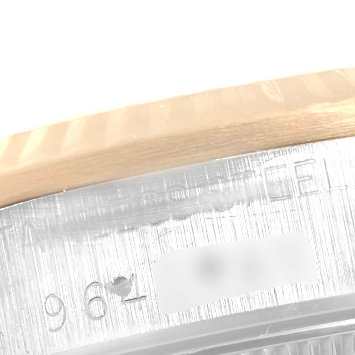 This close-up image of a Rolex Datejust 68273  Women
s Steel and Gold (two tone) Champagne Dial 68273  Women
s Steel and Gold (two tone) Champagne Dial watch shows part of the bezel and serial number inscribed on the case.