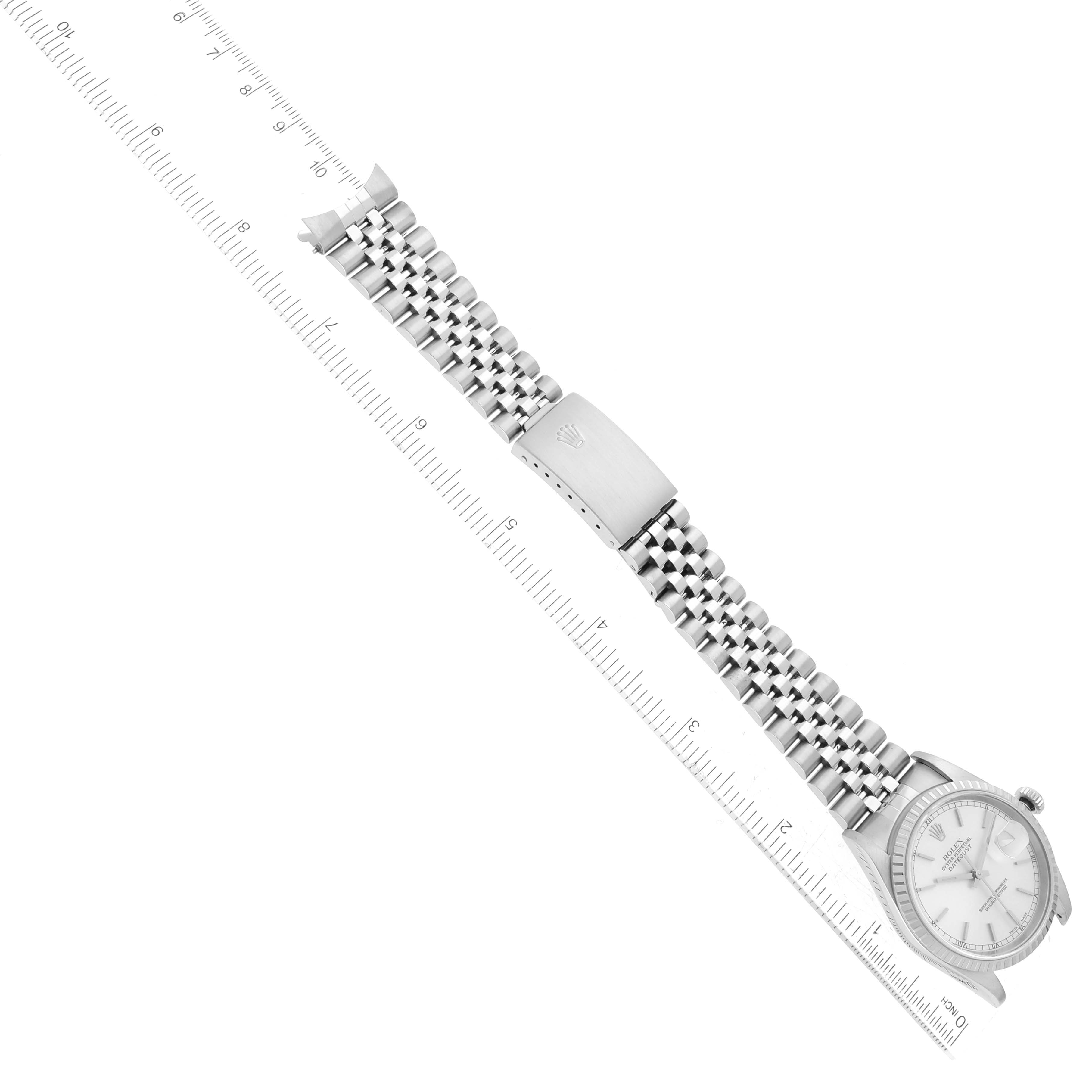 The image shows a Rolex Datejust 16220 Men
s Stainless Steel Silver Dial 16220 Men
s Stainless Steel Silver Dial watch at an oblique angle, highlighting the bracelet and clasp with a millimeter ruler for scale.