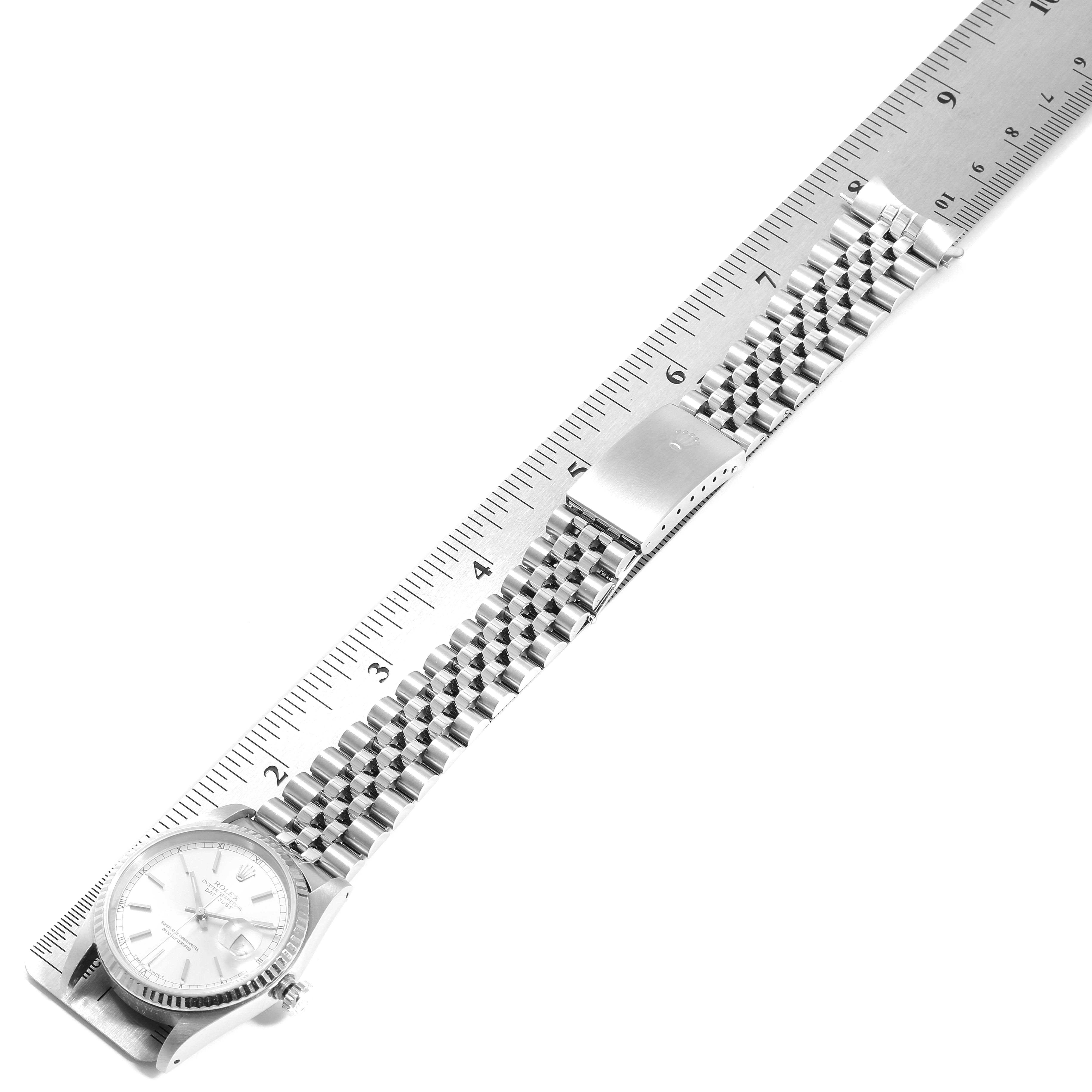 The Rolex Datejust 16234 Men's Stainless Steel Silver Dial 16234 Men's Stainless Steel Silver Dial watch is shown laid flat with a ruler, displaying the face, bracelet, and clasp from a top-down angle.