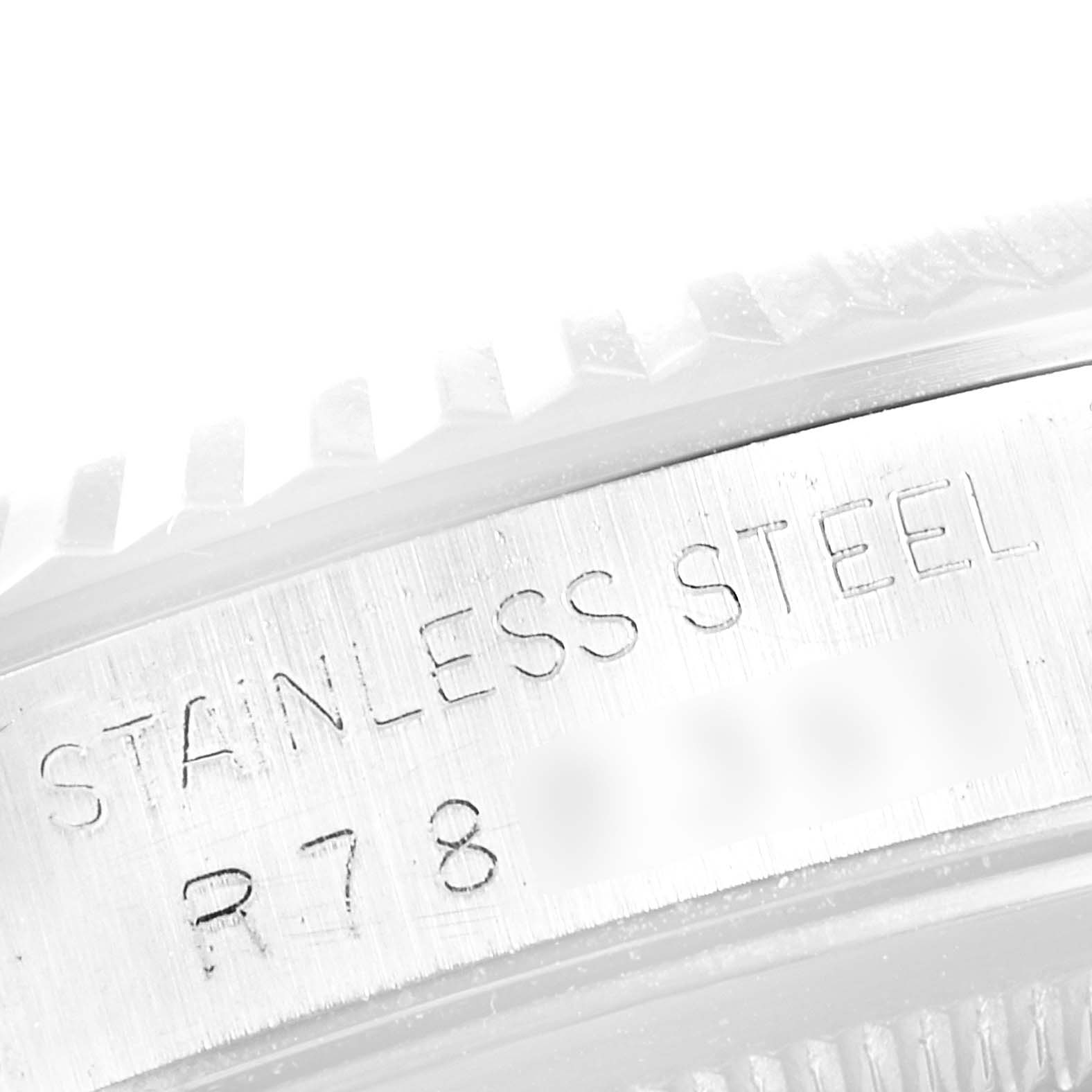 This close-up image shows the side of the bezel and the engraved "STAINLESS STEEL" marking of a Rolex Datejust 16234 Men's Stainless Steel Silver Dial 16234 Men's Stainless Steel Silver Dial watch.