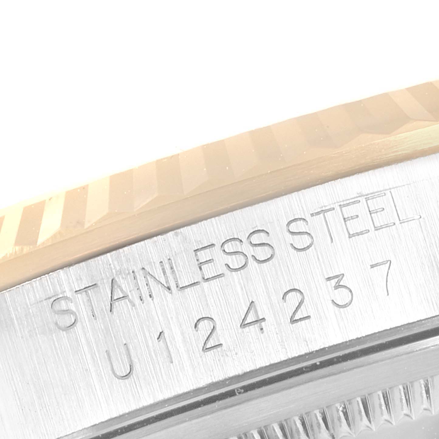 The image shows a close-up of the stainless steel back and edge of the bezel of a Rolex Datejust 16233 Men
s Steel and Gold (two tone) Champagne Dial 16233 Men
s Steel and Gold (two tone) Champagne Dial watch.