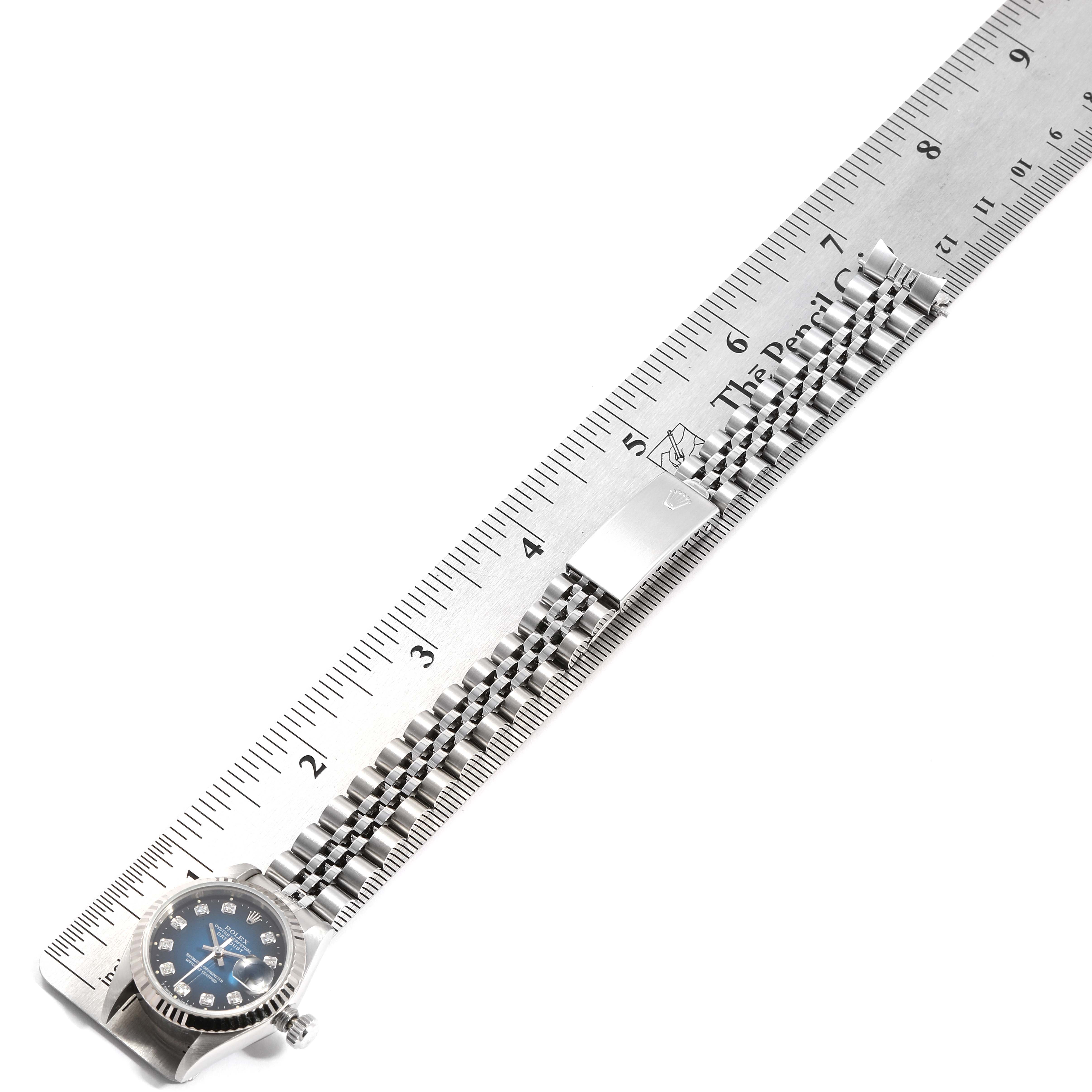 The image shows a Rolex Datejust 69174 Women's Stainless Steel Blue Dial 69174 Women's Stainless Steel Blue Dial watch lying flat next to a ruler, highlighting its bracelet and clasp.