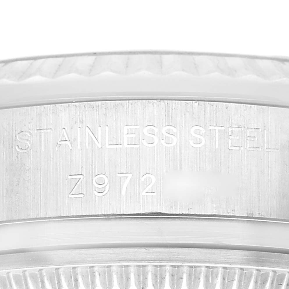 The image shows a close-up of the side of the stainless steel case of a Rolex Datejust 179174 Women
s Stainless Steel Silver Dial 179174 Women
s Stainless Steel Silver Dial watch, featuring engraved text.