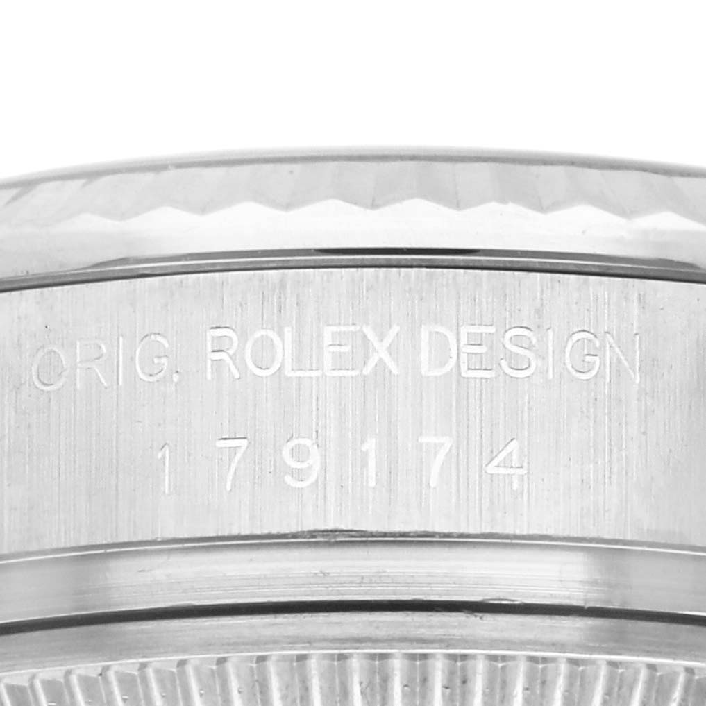 This image shows a close-up of the side of a Rolex Datejust 179174 Women
s Stainless Steel Silver Dial 179174 Women
s Stainless Steel Silver Dial watch, featuring the engraved serial number and "ORIG. ROLEX DESIGN" text.