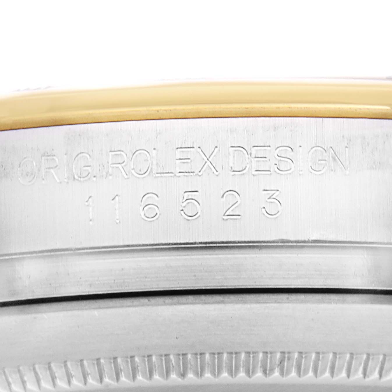 The image shows a close-up of the side of a Rolex Daytona model 116523, focusing on the engraved model number and brand details.