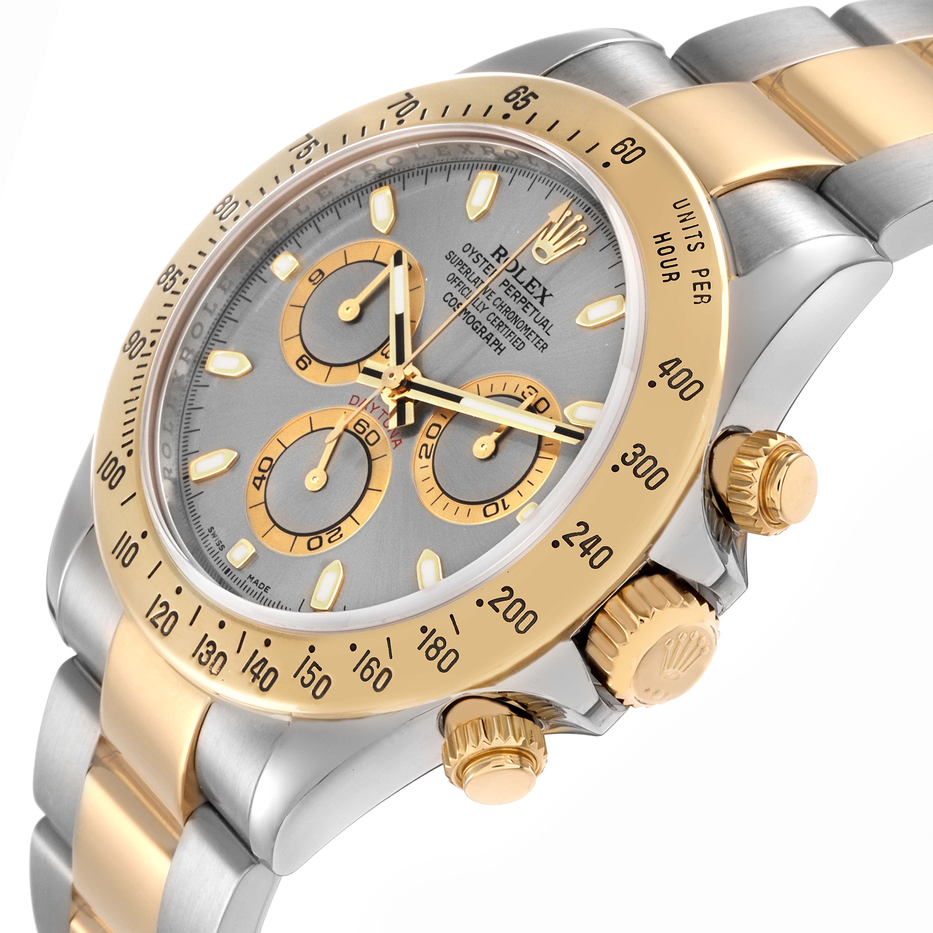 The Rolex Daytona model number 116523 is shown at an angled close-up, highlighting the gold and silver band, bezel, crown, pushers, and part of the dial.
