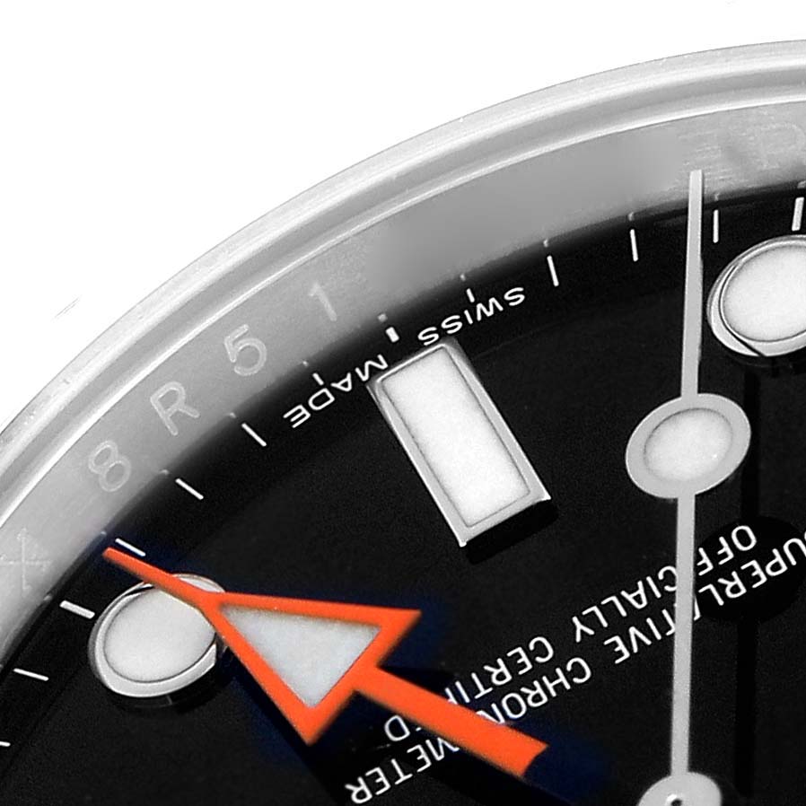 The image shows a close-up of the dial of a Rolex Explorer model 216570 men's watch, focusing on the hour markers, minute hand, and distinctive orange 24-hour hand.