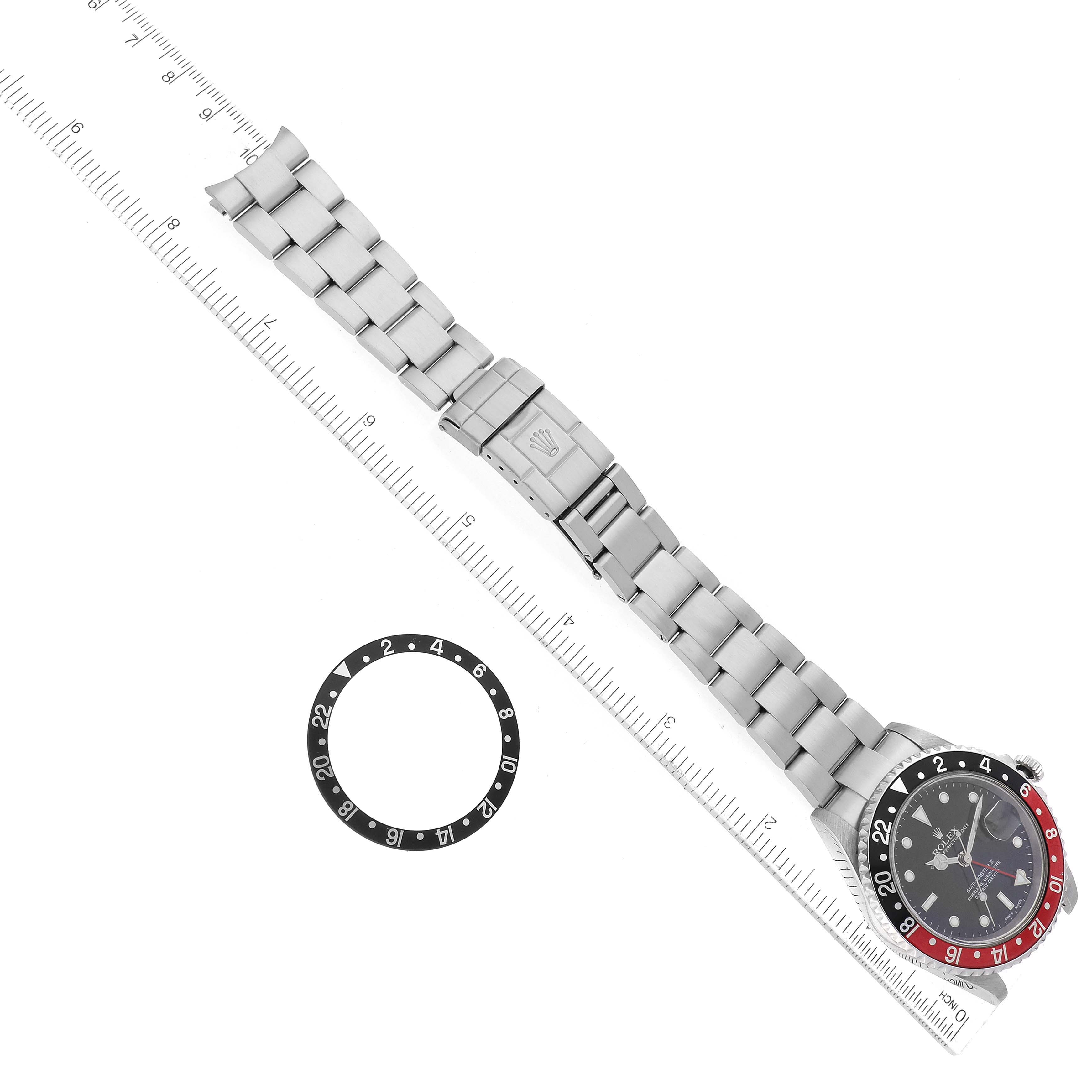 This image shows a top-down view of a Rolex GMT-Master 16710 Men
s Stainless Steel Black Dial 16710 Men
s Stainless Steel Black Dial watch, including the bezel, band, and an additional bezel insert next to it.