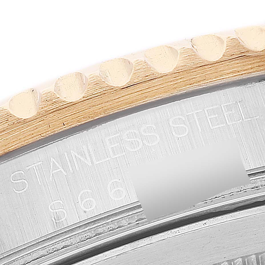 The image shows a close-up of the bezel and part of the case back of a Rolex GMT-Master 16713 Men's Steel and Gold (two tone) Brown Dial 16713 Men's Steel and Gold (two tone) Brown Dial model watch, highlighting the inscription "STAINLESS STEEL."