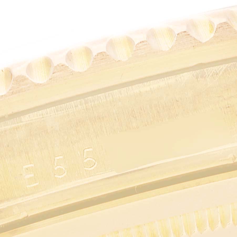 The image shows a close-up of the side of a Rolex GMT-Master 16718 Men's Yellow Gold Black Dial bezel, highlighting the textured edge and engraved numbers.