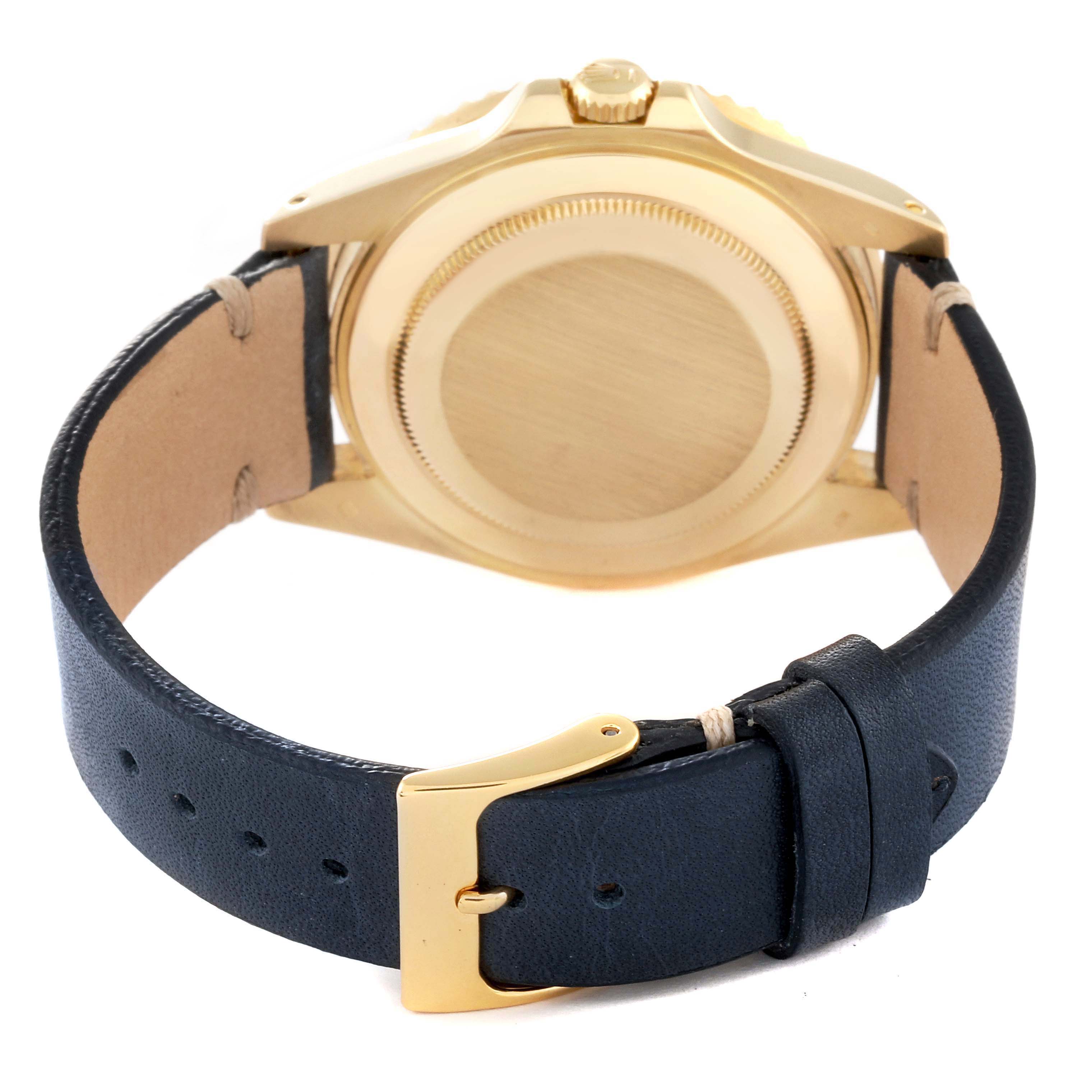 The Rolex GMT-Master 16718 Men's Yellow Gold Black Dial is shown from the back, highlighting the case back and leather strap with a gold buckle.