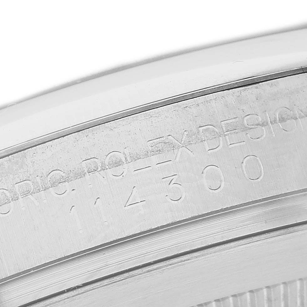 The image shows a close-up of the engraved side of the Rolex Oyster Perpetual 114300 Men's Stainless Steel Grey Dial watch, displaying its model number.
