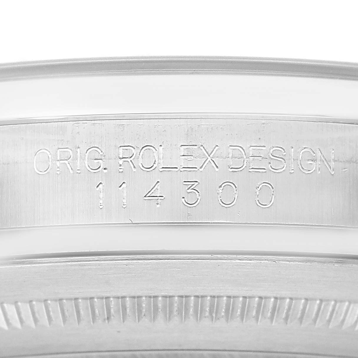 The image shows a close-up of the side of a Rolex Oyster Perpetual 114300 Men's Stainless Steel Grey Dial watch, highlighting the engraved model number "114300."
