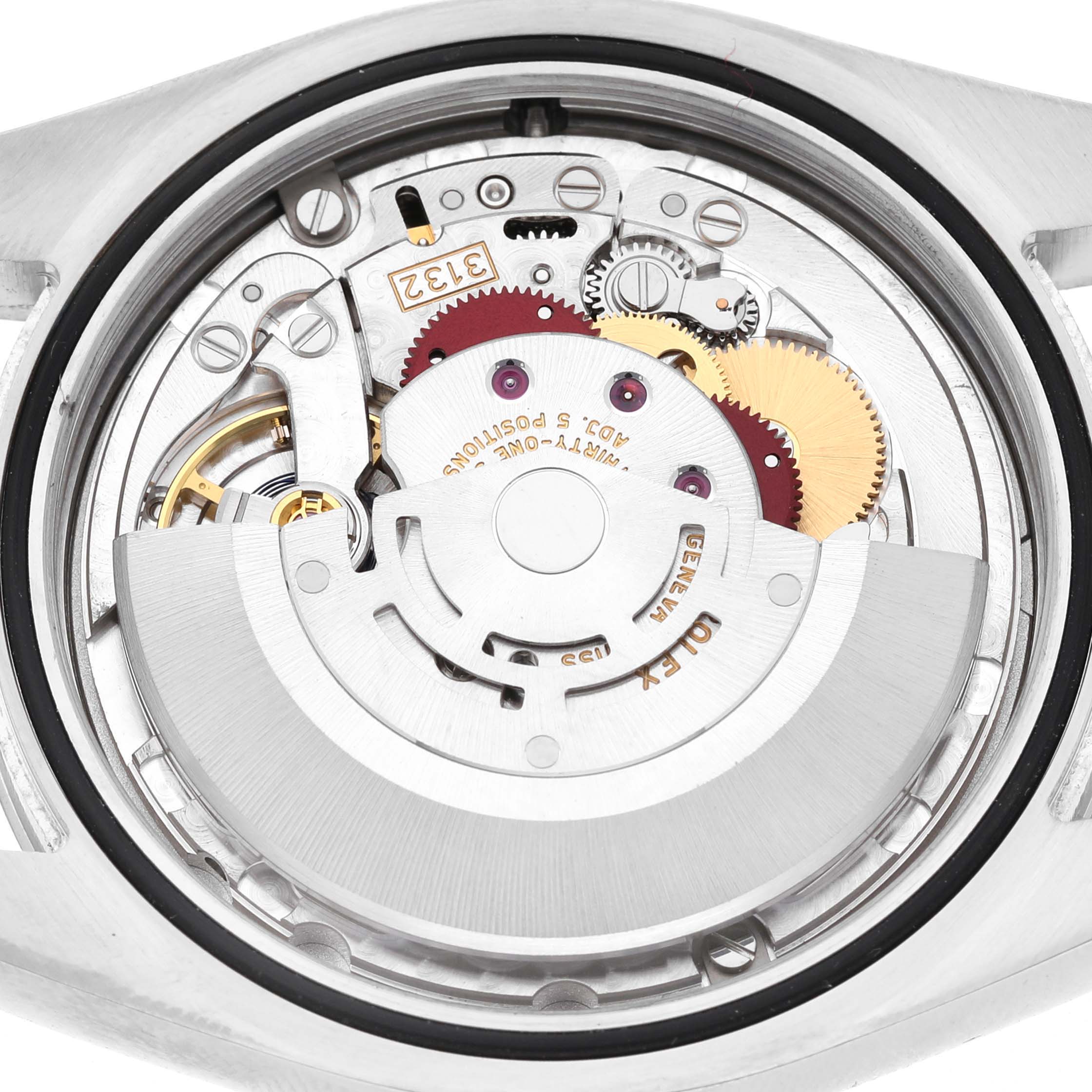 The image shows the back view of a Rolex Oyster Perpetual 114300 Men's Stainless Steel Grey Dial, revealing its intricate internal movement parts.