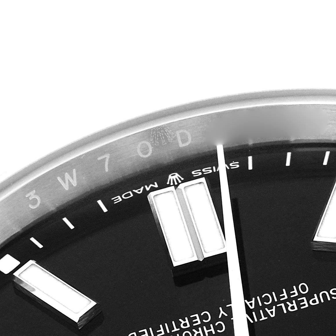 The image shows a partial close-up of the dial and markers of the Rolex Oyster Perpetual model 124300, highlighting the indices and part of the text.
