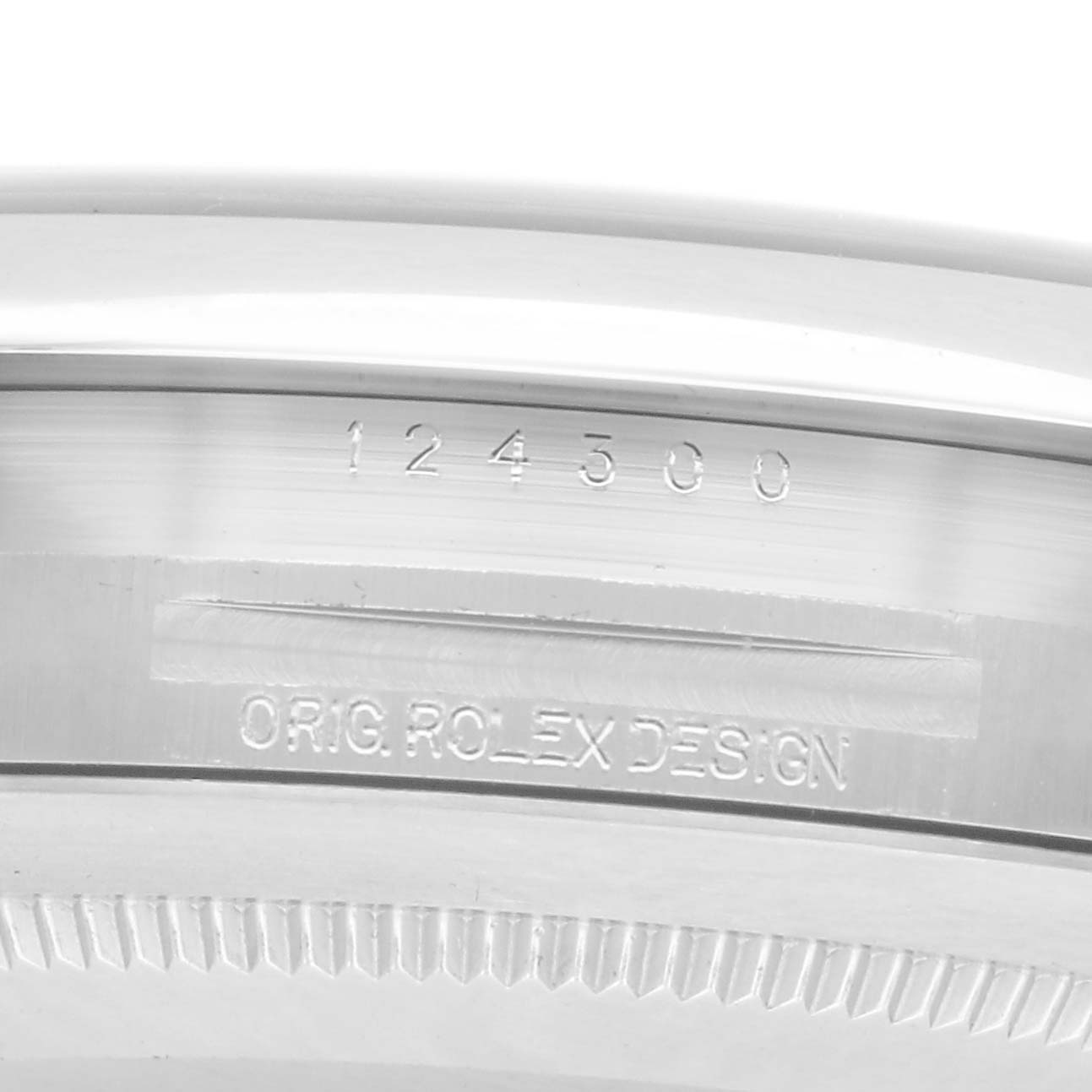 The image shows a close-up of the Rolex Oyster Perpetual model number 124300, specifically focusing on the engraved reference number and "Orig Rolex Design" on the case.