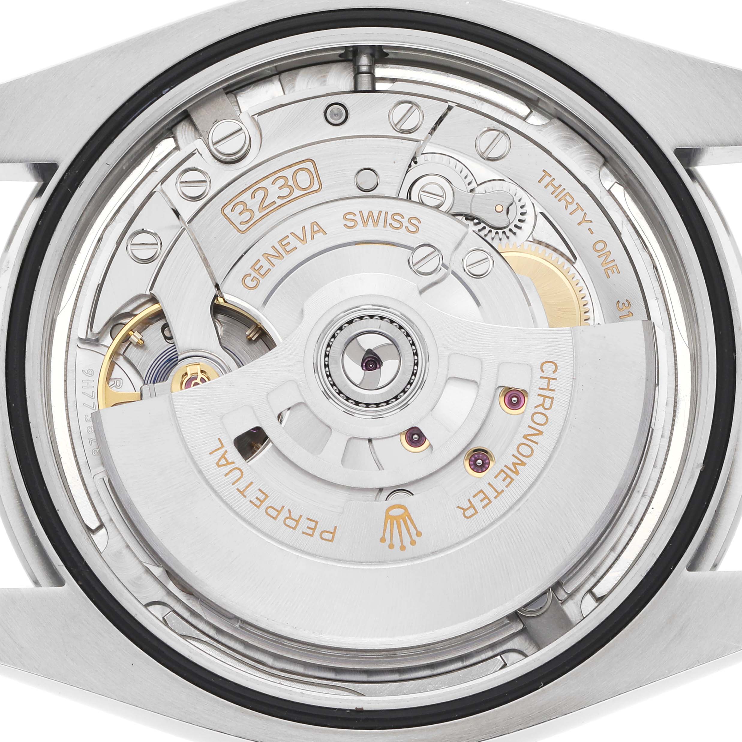 The image shows the movement of the Rolex Oyster Perpetual model 124300, focusing on the intricate details of the internal mechanical parts from a top-down angle.