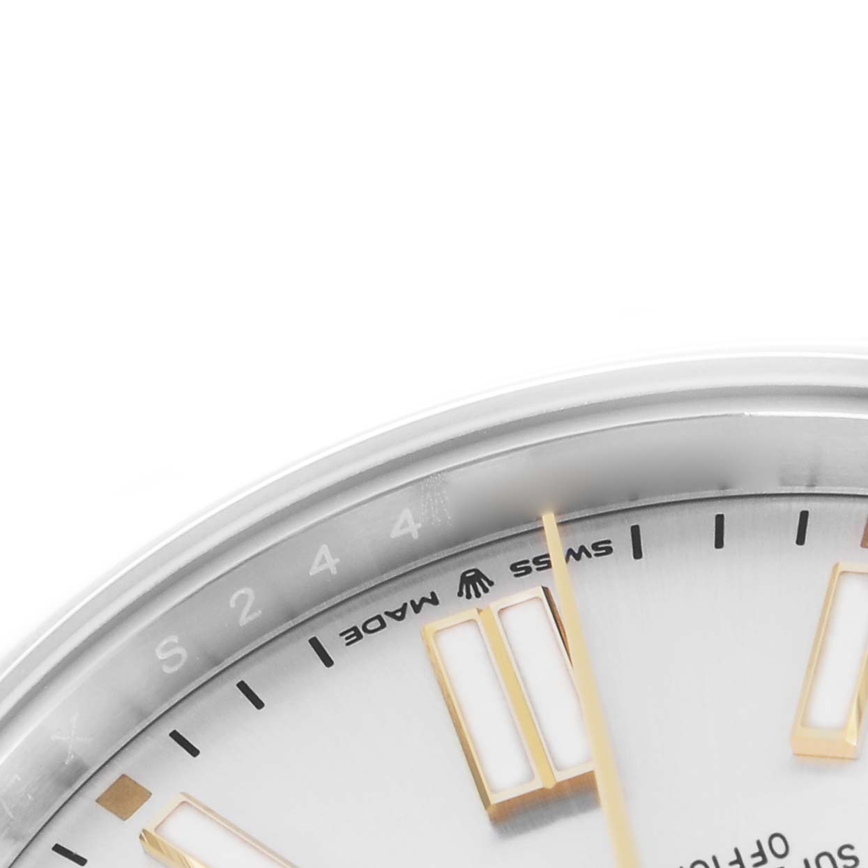 The image shows the upper portion of a Rolex Oyster Perpetual model 124300 watch face, featuring a segment of the dial with markers and a partial "Swiss Made" label.