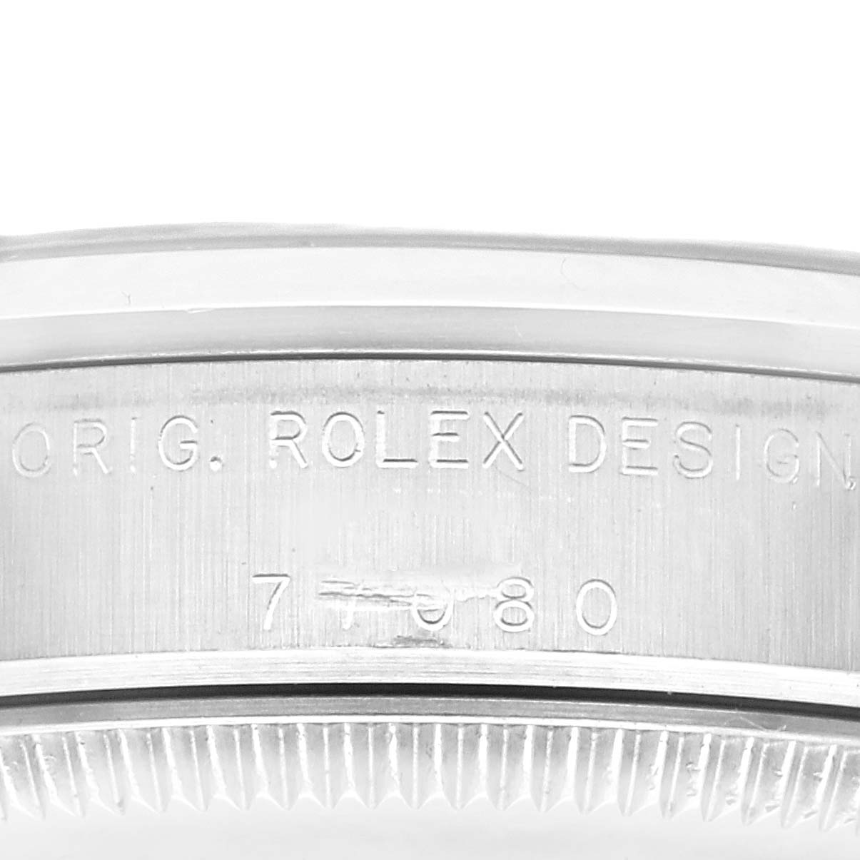 The image shows an angled close-up of the case back of a Rolex Oyster Perpetual watch, displaying its design and serial number.