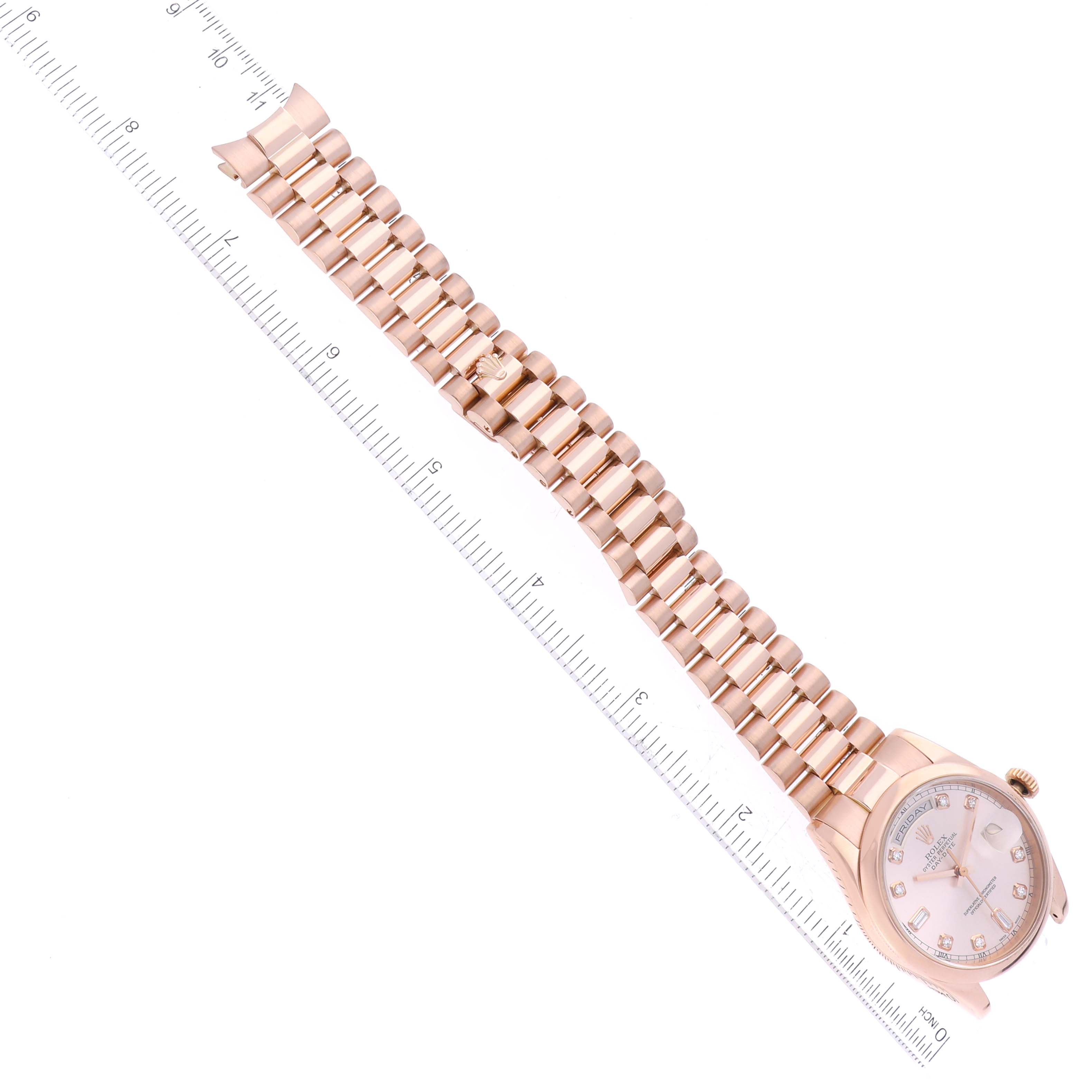 The image shows a Rolex President 118205 Men's Rose Gold Pink Dial 118205 Men's Rose Gold Pink Dial model watch lying flat with the strap extended next to a ruler.