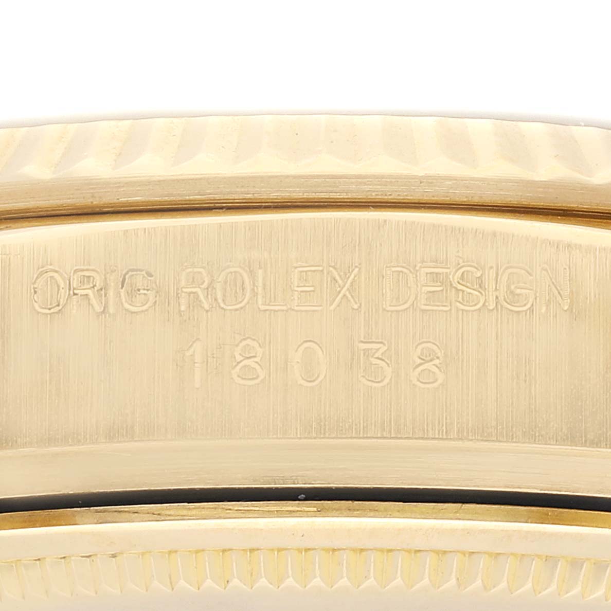 This is a close-up of the side of a Rolex President 18038 Men
s Yellow Gold Champagne Dial 18038 Men
s Yellow Gold Champagne Dial model watch showing the case with engraved text and ridges.