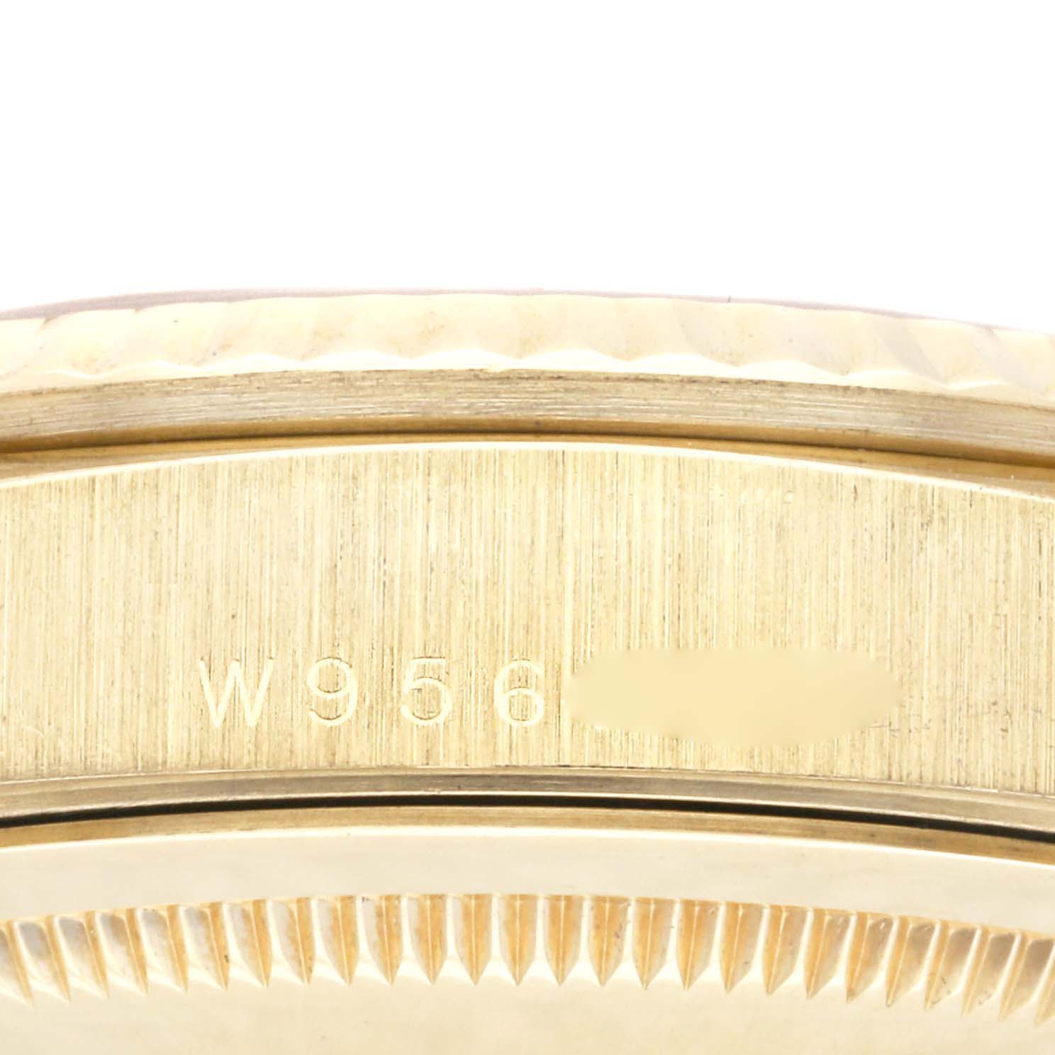 This image shows a close-up of the side of a Rolex President 18238 Men
s Yellow Gold Champagne Dial 18238 Men
s Yellow Gold Champagne Dial watch, highlighting its fluted bezel and a partial serial number.
