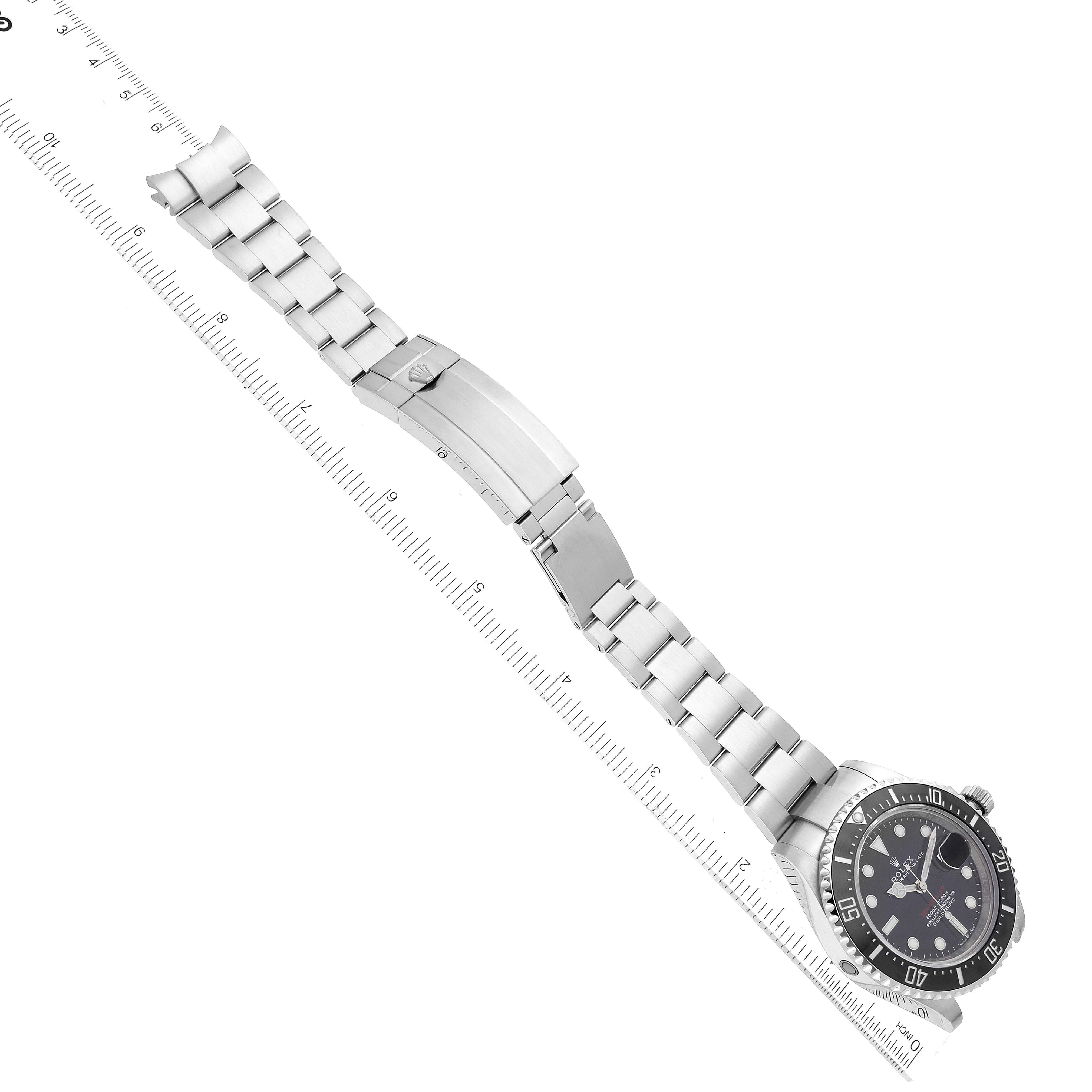 The image shows a Rolex Sea-Dweller 126600 Men
s Stainless Steel Black Dial 126600 Men
s Stainless Steel Black Dial watch laid flat from above, highlighting its bracelet and clasp alongside a ruler for scale.
