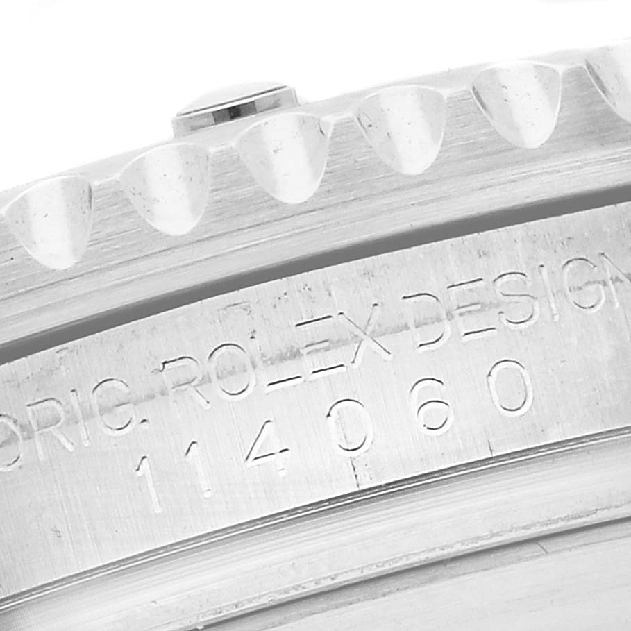 The image shows a close-up of a Rolex Submariner 114060 Men
s Stainless Steel Black Dial 114060 Men
s Stainless Steel Black Dial model, highlighting the engraved model number on its case side.