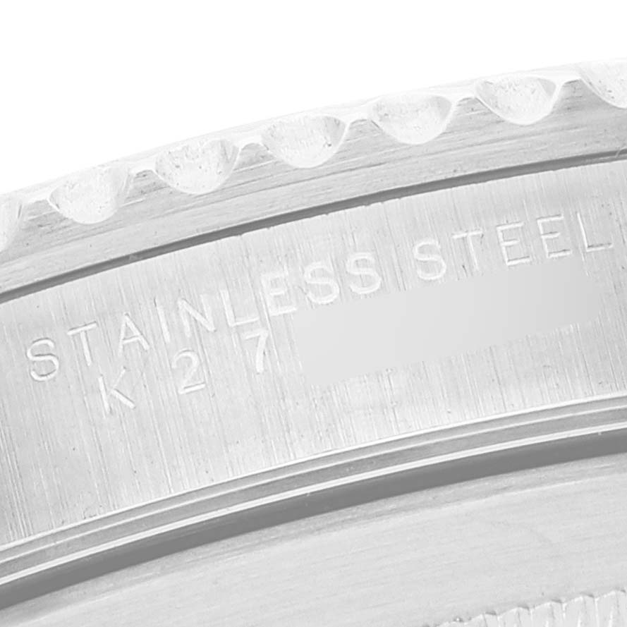 The image shows the engraved side of a Rolex Submariner 14060 Men
s Stainless Steel Black Dial 14060 Men
s Stainless Steel Black Dial watch case, indicating "STAINLESS STEEL" and part of its serial number.