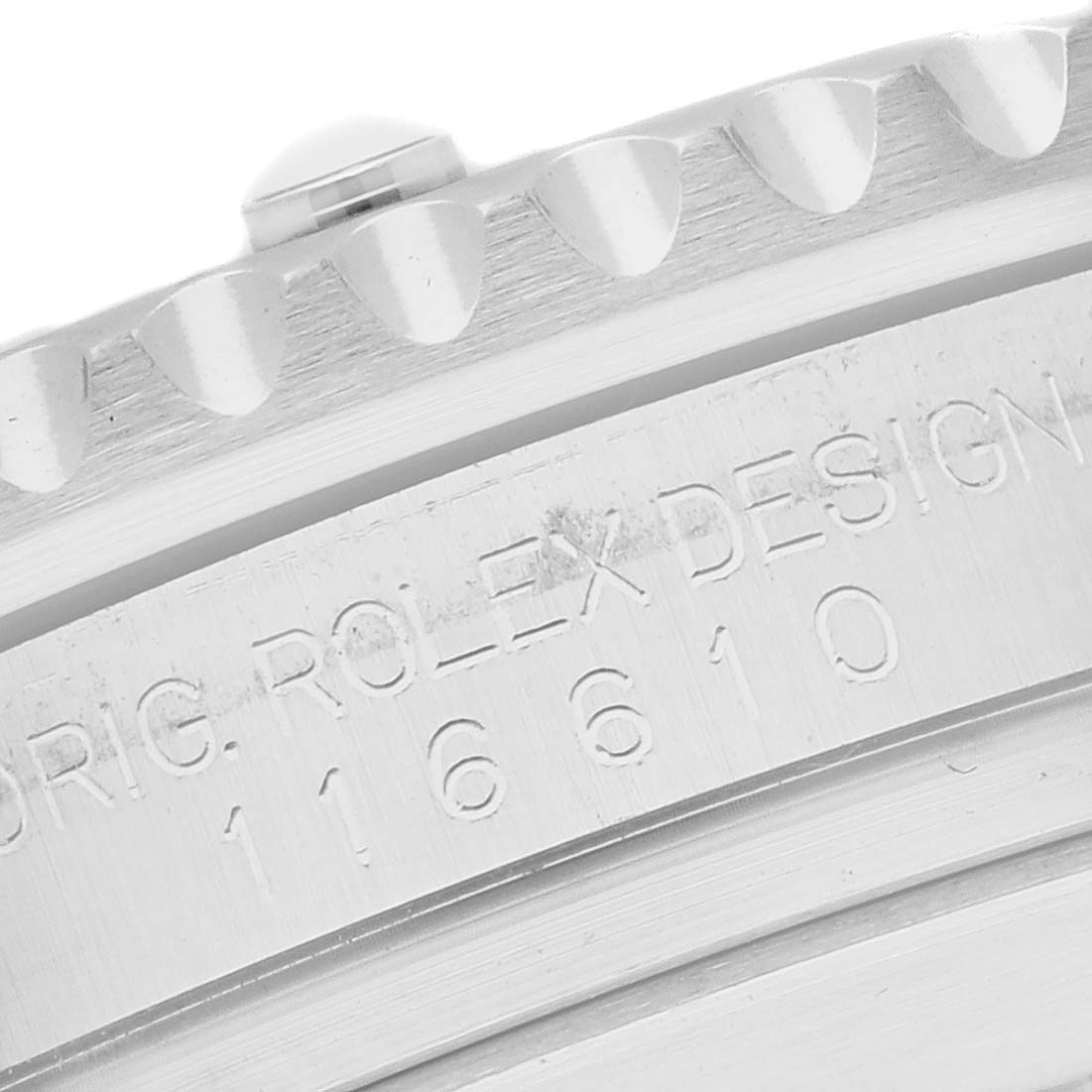 The image shows a close-up of the bezel and engraved side of the Rolex Submariner model 116610.