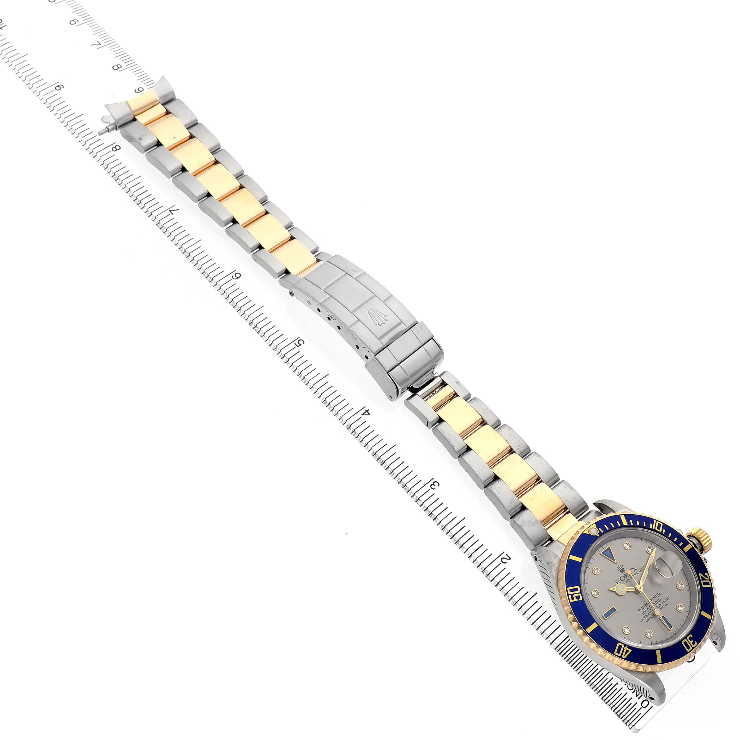 The Rolex Submariner 16613 Men's Steel and Gold (two tone) Champagne Dial is shown at a diagonal angle, displaying the bracelet, clasp, dial, and bezel.